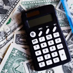 Image of a caluclator and a pen resting on a pile of American 1 dollar bills