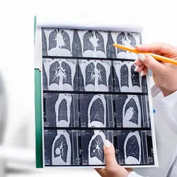 Health care rpovider looking at MRI images with MRI machine in background
