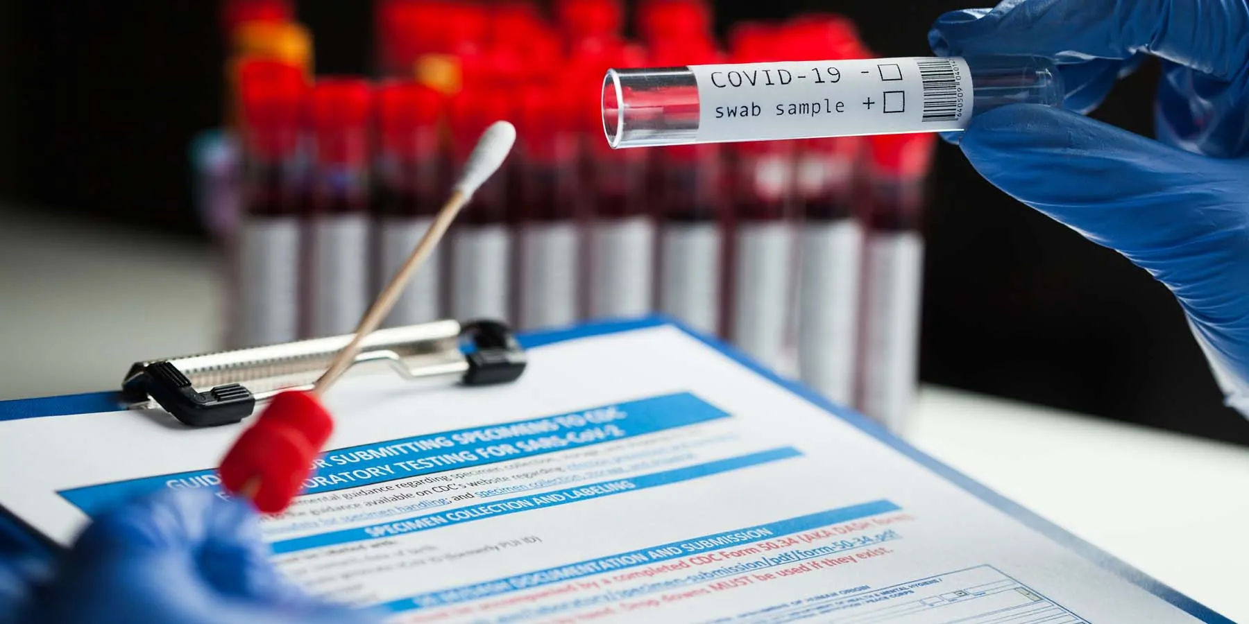 Health care provider with a COVID-19 test swab and clipboard