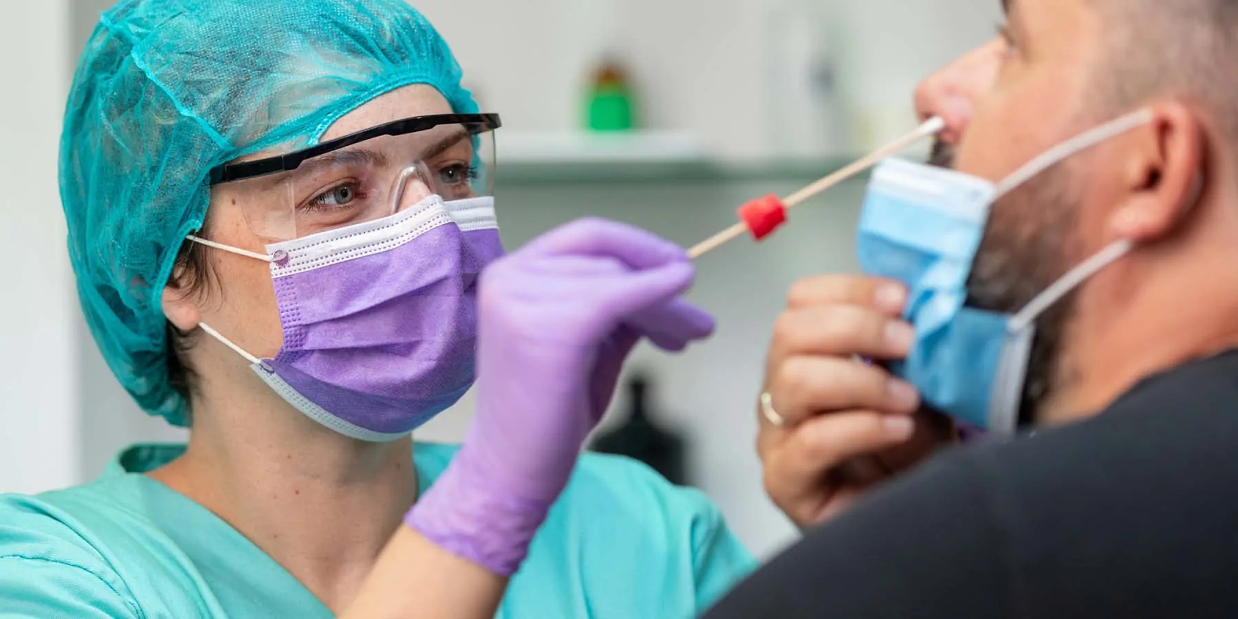 Simple, Complete Solution for Labs Preparing for OSHA Testing Requirements Professional administering a nasal swab for a COVID-19 test