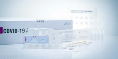 Componants of various COVID-19 testing kits resting on a white background