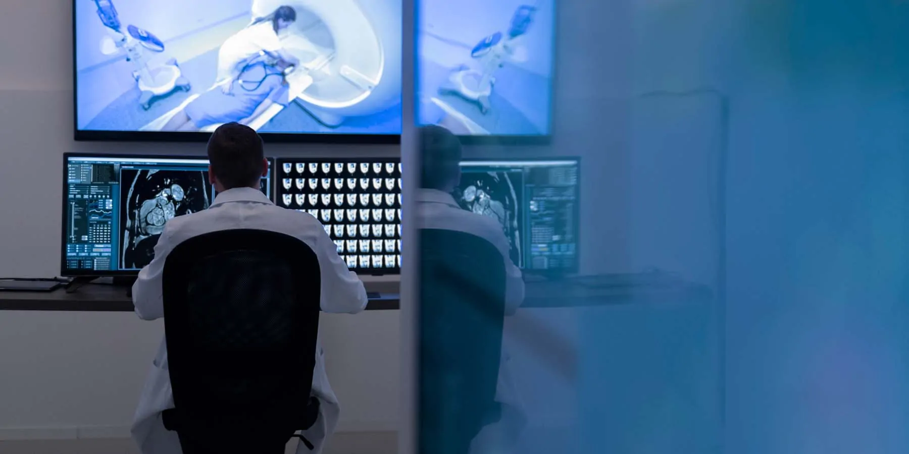 Health care provider sitting in front of a screen showing MRI images