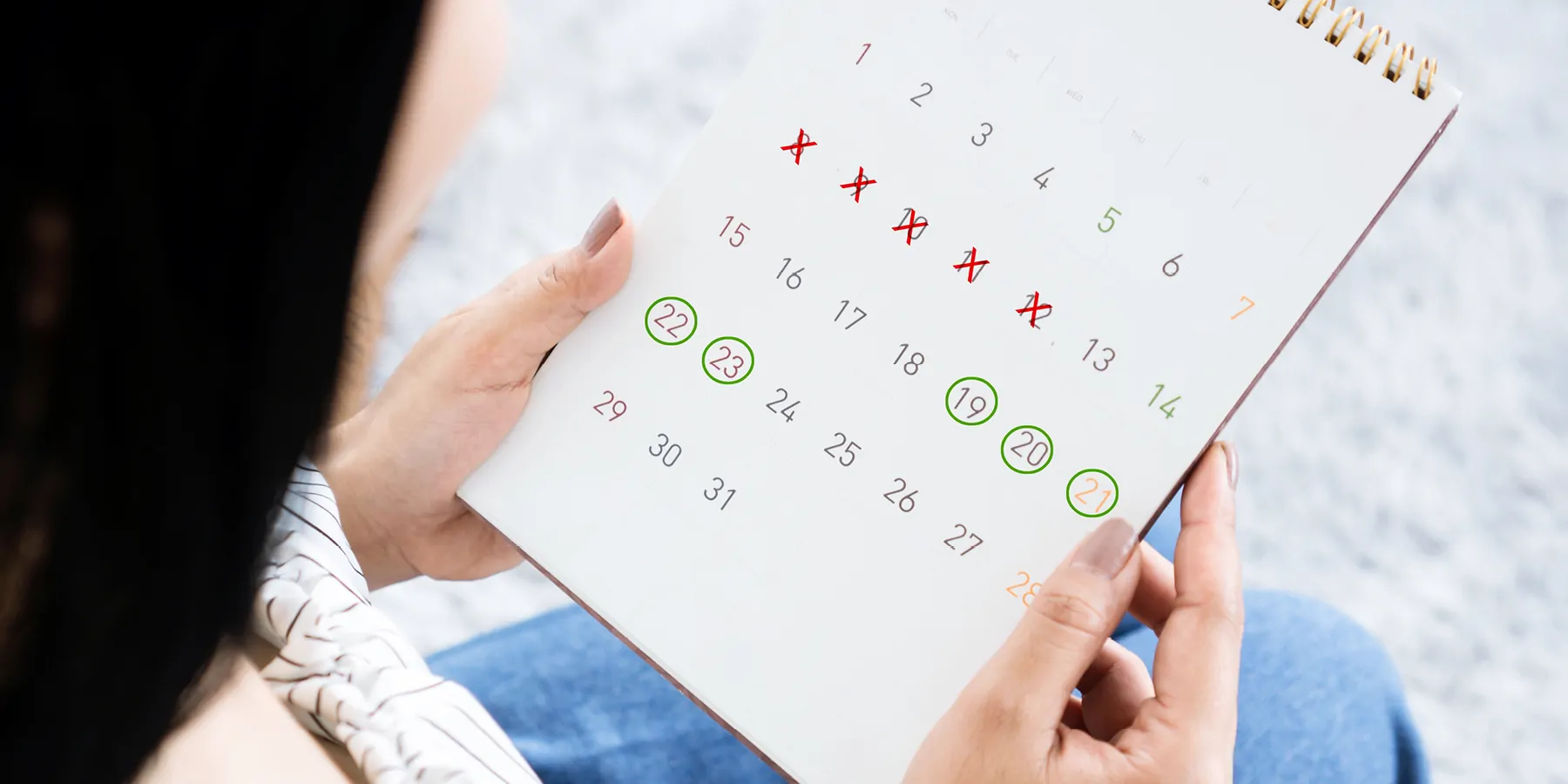 Woman looking at a calender that is tracking her menstral cycle