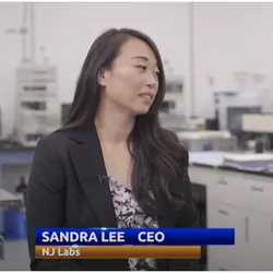 Host and co-host of the new podcast speaking to the camera with a lab in the background