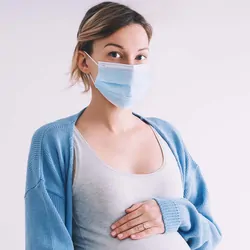 A pregnant women wearing a mask on a white background
