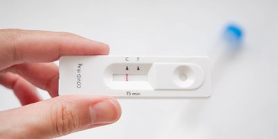 Person holding a rapid antigen test that is negative