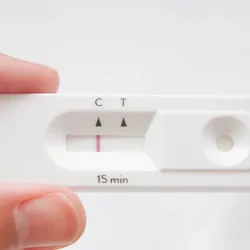 Person holding a rapid antigen test that is negative