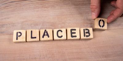 Letter blocks that spell the word "Placebo" on a table