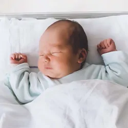 Newborn baby sleeping in a hospital crib