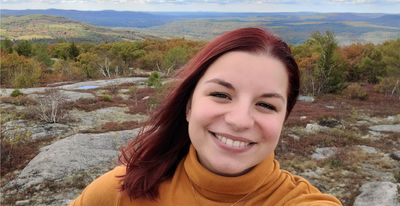 Photo of Julie Sense with a nature scene with mountains in the background.