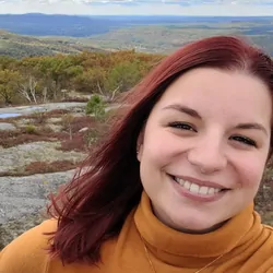 Photo of Julie Sense with a nature scene with mountains in the background.