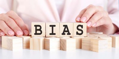 Women lining up blocks that spell the word "Bias"