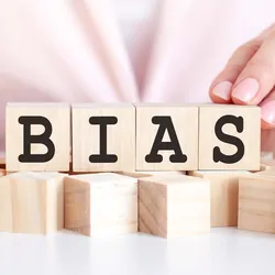 Women lining up blocks that spell the word "Bias"