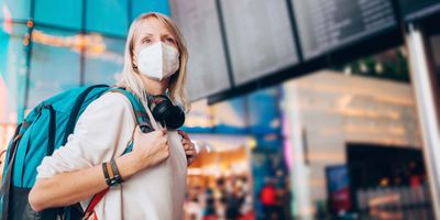 Women wearing mask traveling through an airport