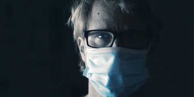 Photo of a man with glasses wearing a mask against COVID-19