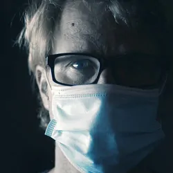 Photo of a man with glasses wearing a mask against COVID-19