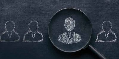 Illustration of a person silhouette drawn on a chalkboard in the middle of a magnifying glass.