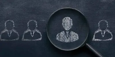 Illustration of a person silhouette drawn on a chalkboard in the middle of a magnifying glass.