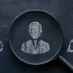 Illustration of a person silhouette drawn on a chalkboard in the middle of a magnifying glass.
