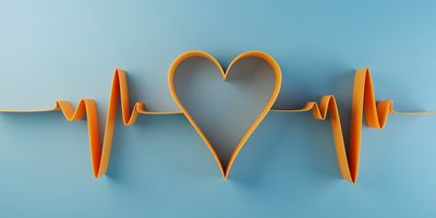 Paper cut out of a heart rate wave that forms a hear in the center, on a blue background