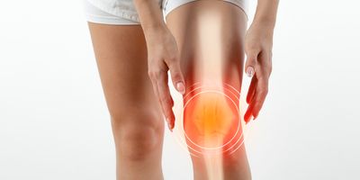 Women with knee pain on a white backdrop