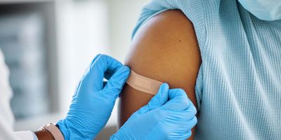 Photo of a clinical professional giving a child a Dengvaxia vaccine against dengue fever.