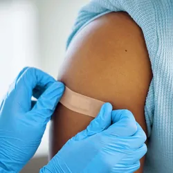 Photo of a clinical professional giving a child a Dengvaxia vaccine against dengue fever.