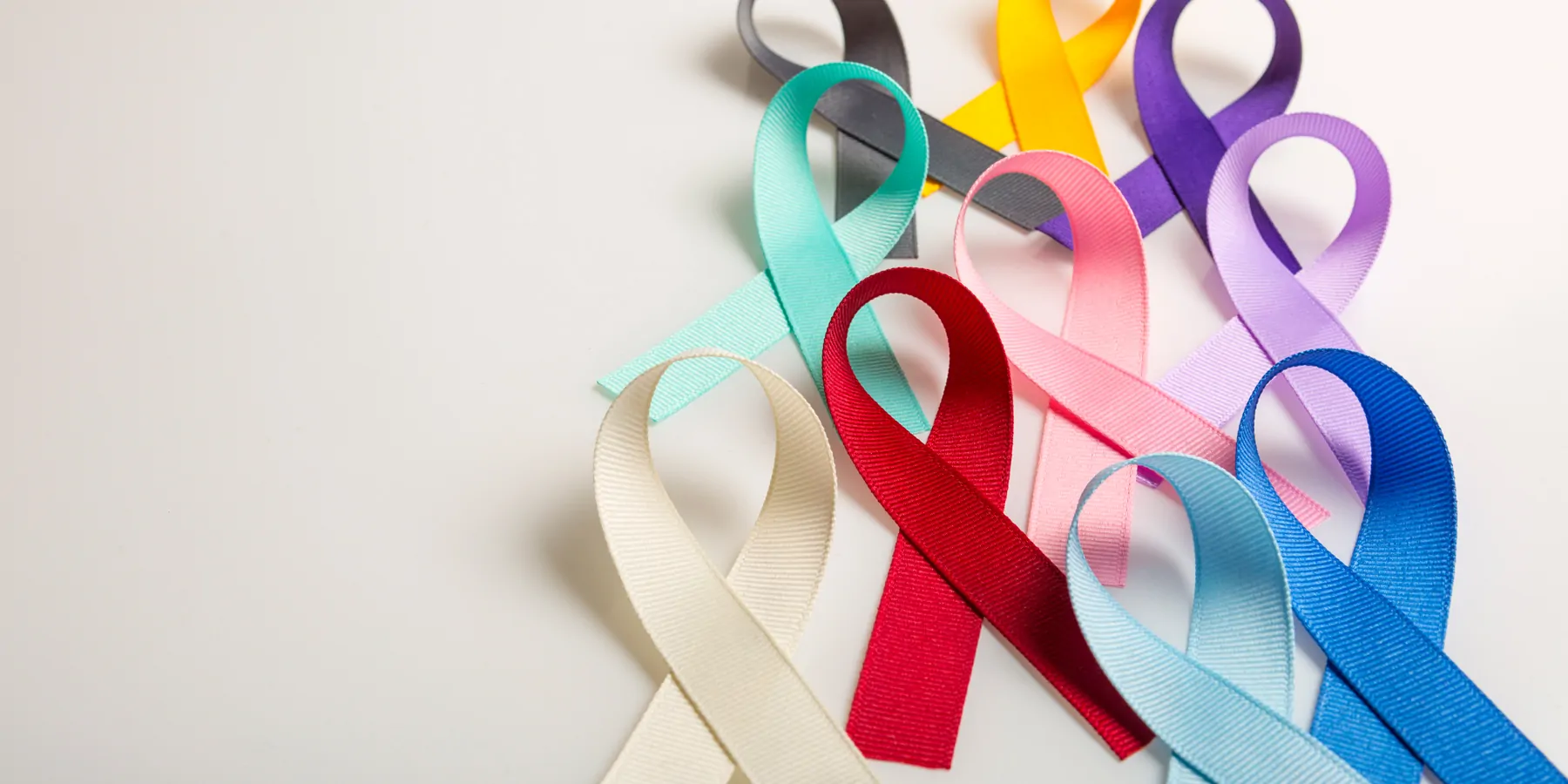 Cancer ribbons of various colors laid on a white table