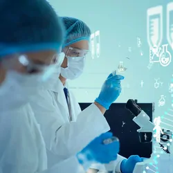 Researchers in PPE in front of microscopes working