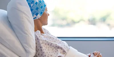 Cancer patient laying in hospital bed, looking out the window
