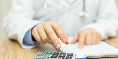 Photo of a clinical lab professional preparing a patient financial statement using a calculator.