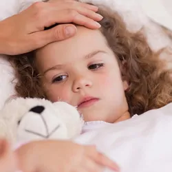 Young girl, sick in bed with mother checking her temperature