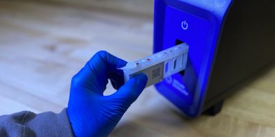 A person puts a sample into the DASH unit.