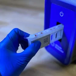 A person puts a sample into the DASH unit.