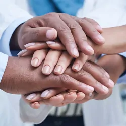 Diverse group of health care workers with hands together