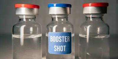 Three bottles containing vaccine booster shots