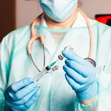 Photograph of health care worker carrying out a molecular test immediately with their patient in the room.
