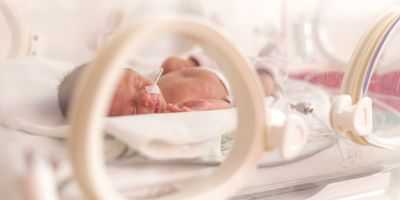 Preterm baby in an incubator being treated
