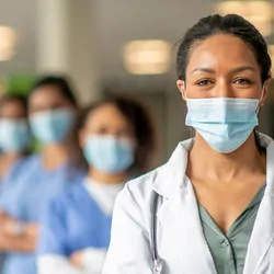 Health care profesionals wearing masks and facing the camera looking determined