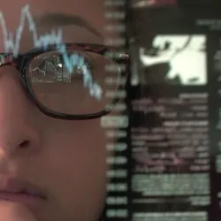 Woman concentrating on a touch screen display to look at data for real-time monitoring of the lab environment.  