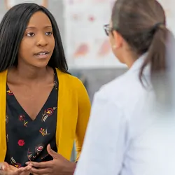 A patient consults with her doctor regarding her cancer risk following BRCA genetic testing.