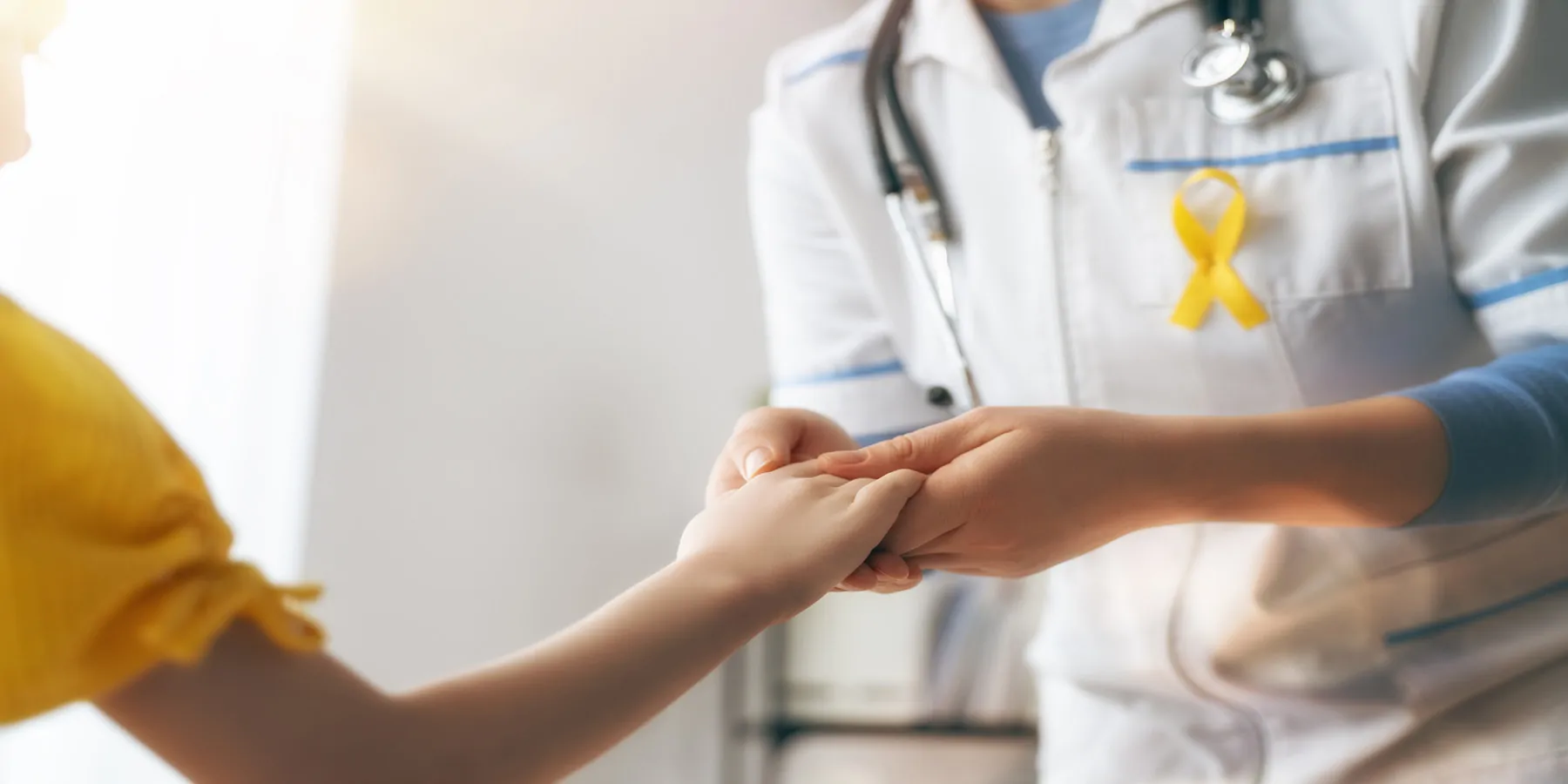 Doctor holding hands with a child who has cancer