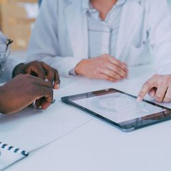 Two health care professionals examining a breast cancer patient's diagnostic information