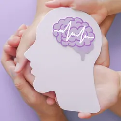 Hands holding a cut out of a human head in profile, with a paper brain on a pink background