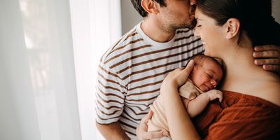 Photograph of a father with diabetes and mother taking care of their newborn, who may be more susceptible to genetic risks if metformin was consumed by his father just prior to conception. 