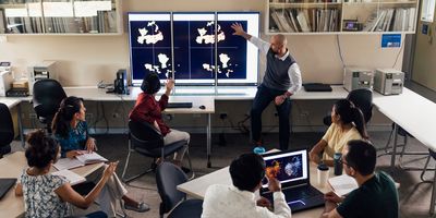 Photo of a clinical laboratory professional giving a presentation to high school students.