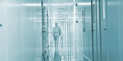 Clinical biobank professionals wearing PPE walking down a hall in the specimen biobank.