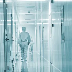 Clinical biobank professionals wearing PPE walking down a hall in the specimen biobank.