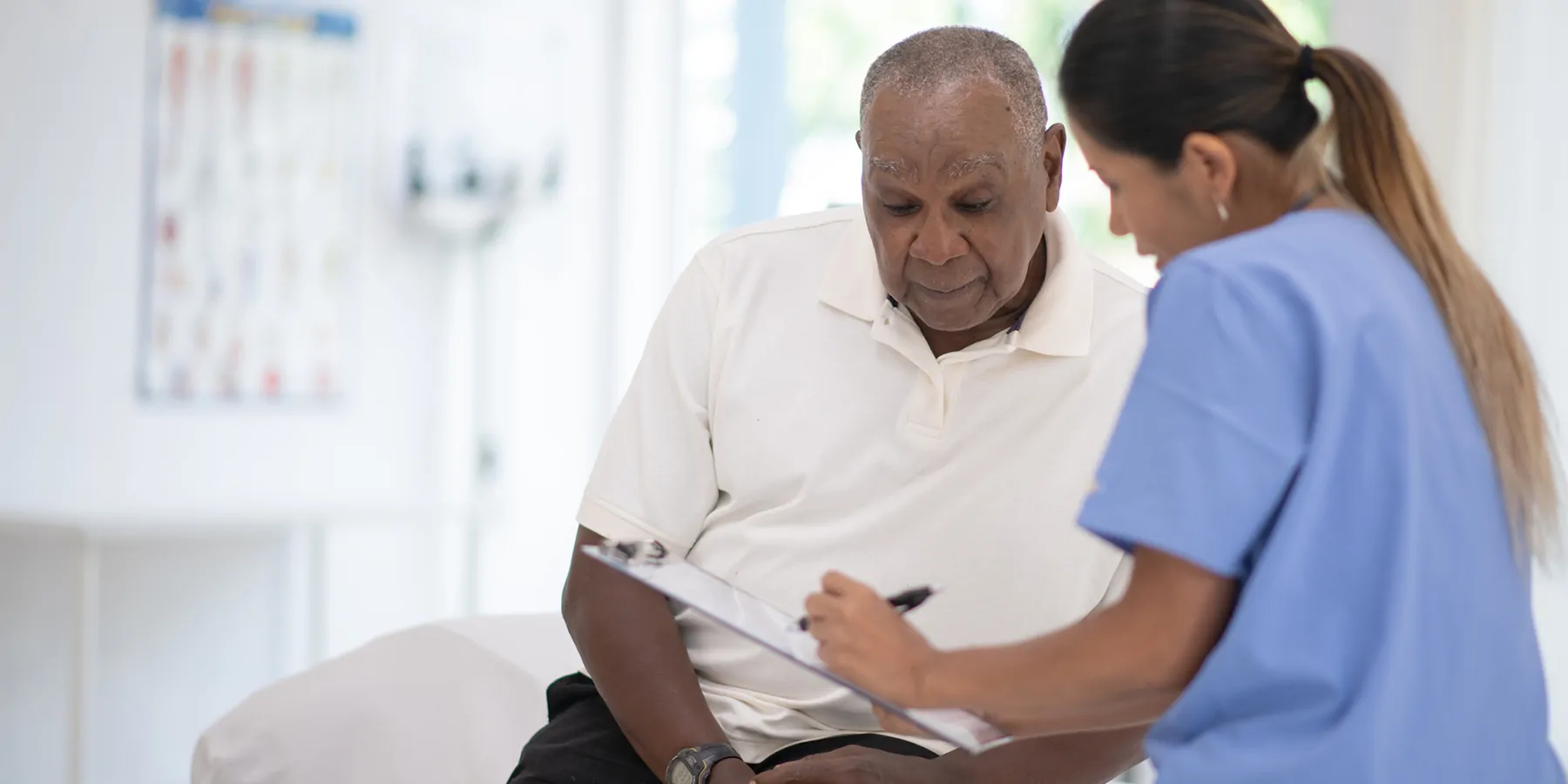 Photograph of a man and a clinical professional discussing results of his prostate cancer tests.