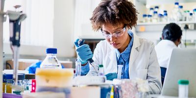 Photograph of a clinical lab professional using a well calibrated pipette for liquid handling in her experiments.